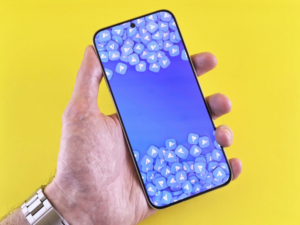 Hand holding a smartphone with a blue screen.